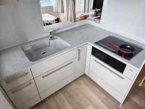 リフォーム後：明るく開放的になった新しいL型キッチン全景