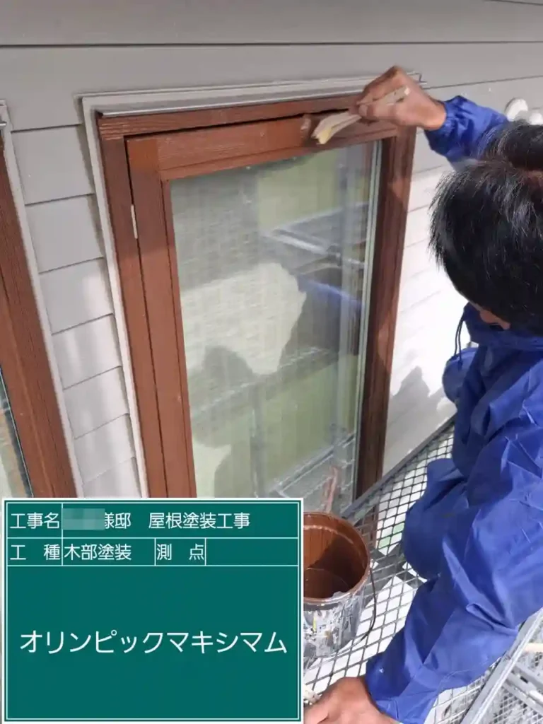 施工中：木製サッシへの塗料塗布作業の様子