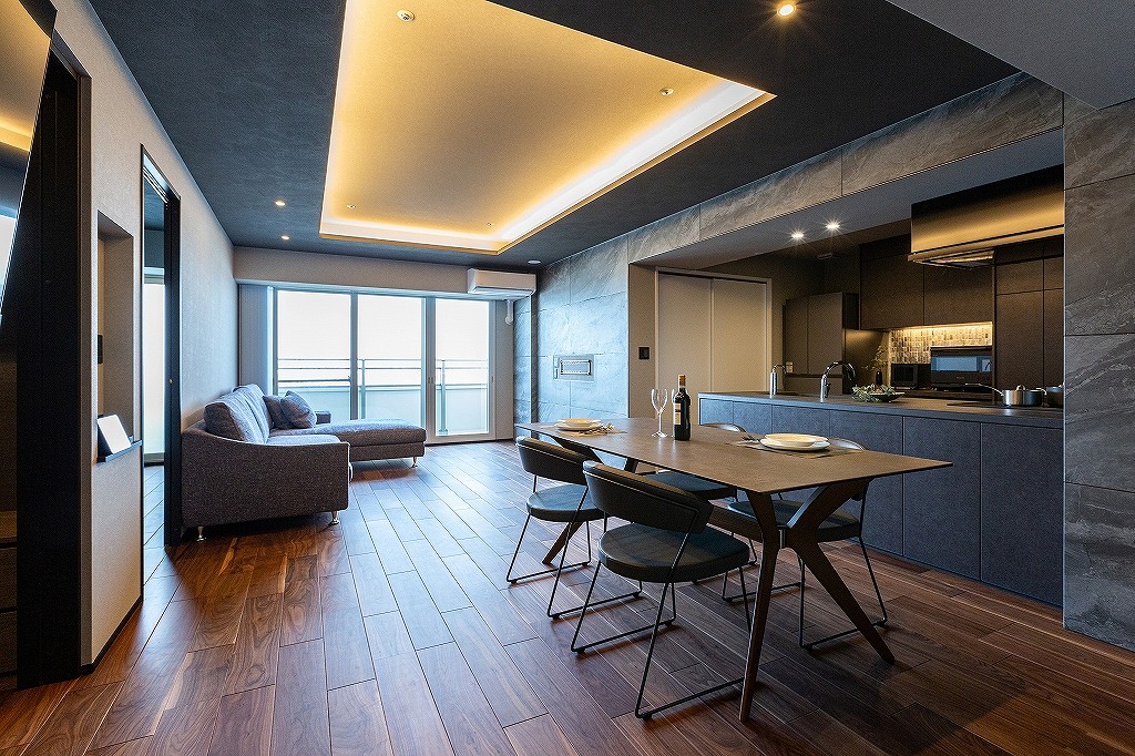 リノベーション後:ブラックウォールナット床材と大判タイルを使用したホテルライクなリビング空間