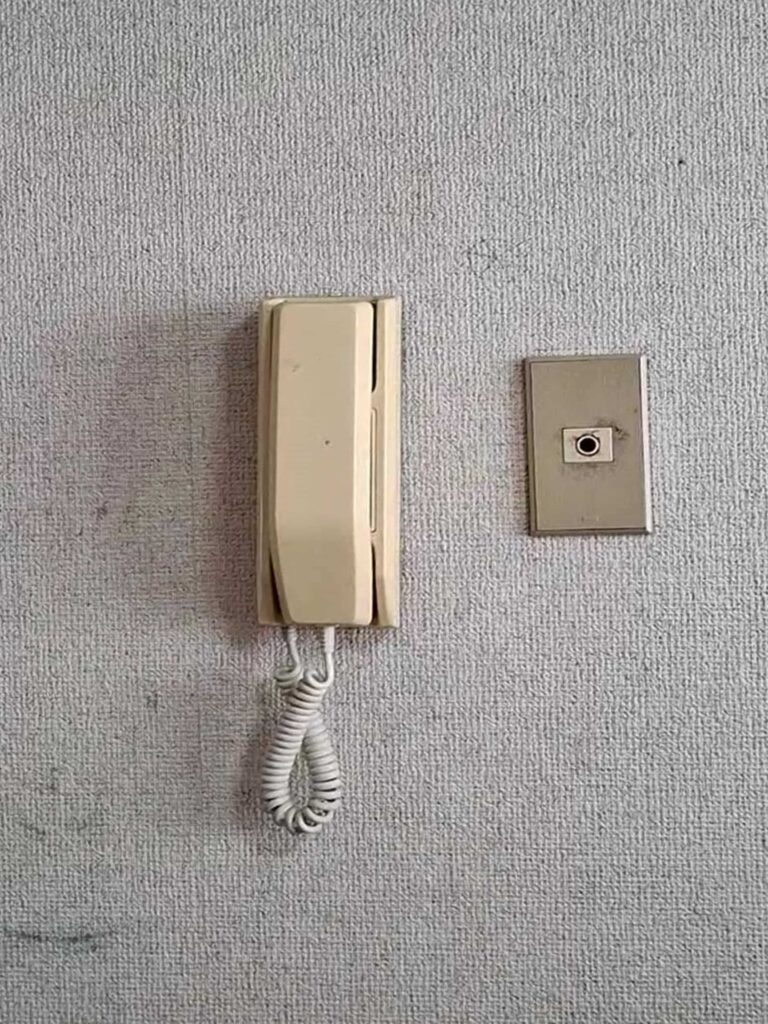 リフォーム前:経年劣化した旧型インターホンの操作パネル