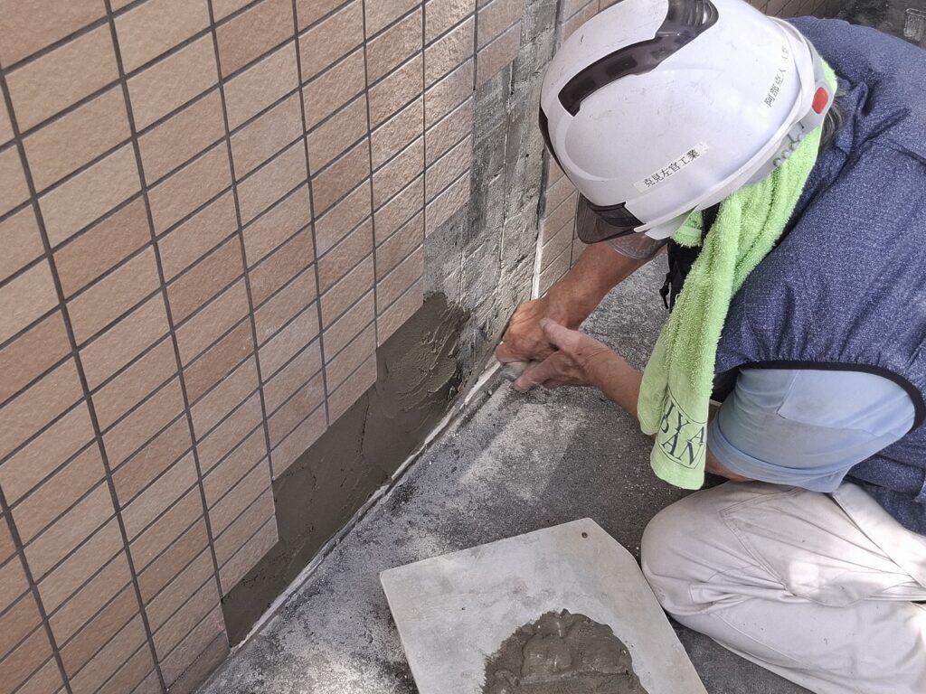 外壁タイル補修工事の施工中の様子:タイルの補修作業を行っている場面