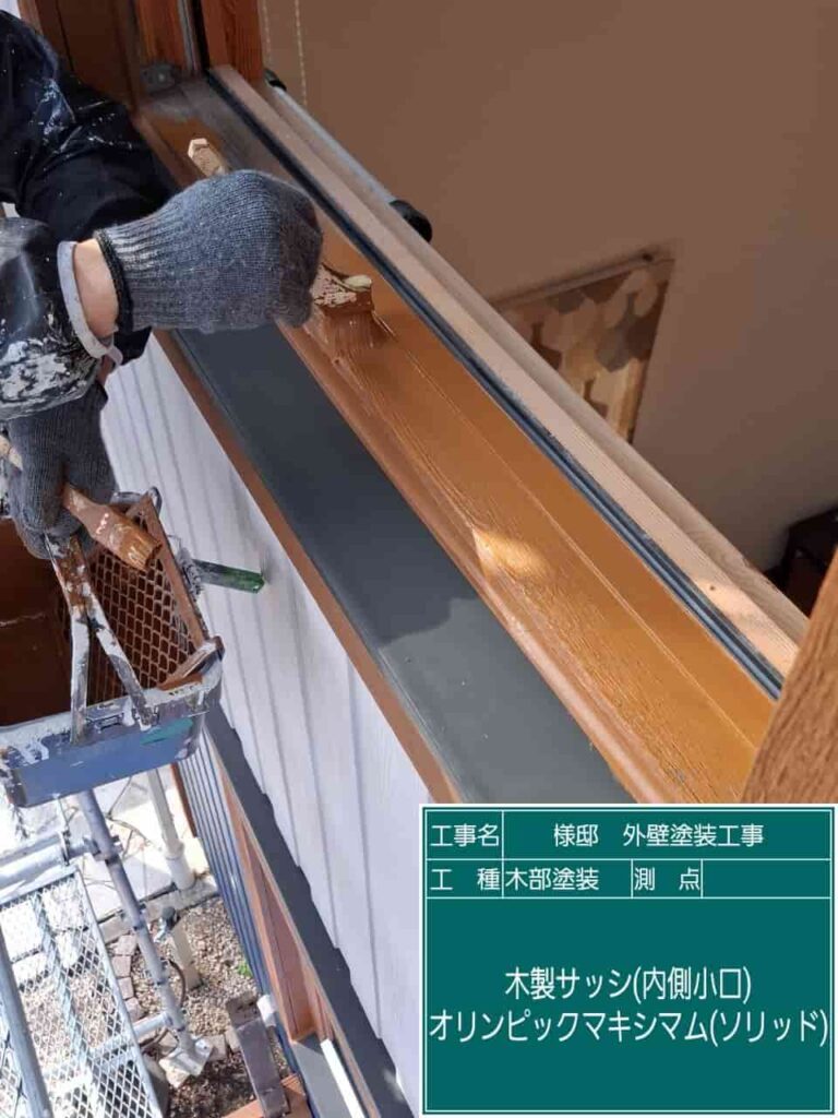 木製窓枠を塗装している作業風景