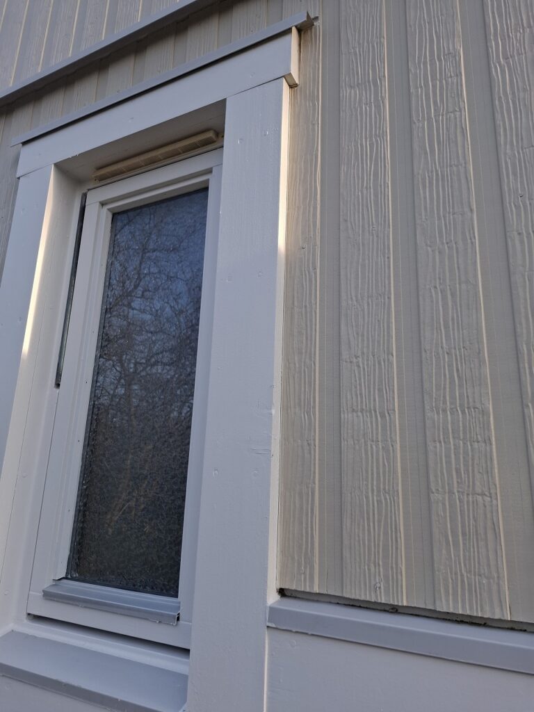 リフォーム後：美しく塗り替えられた木製窓枠の縦アングル