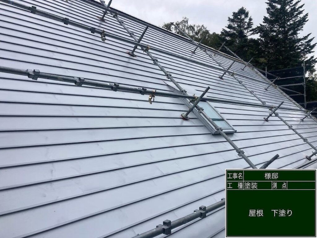 屋根塗装施工中:屋根への下塗り塗料の塗布作業