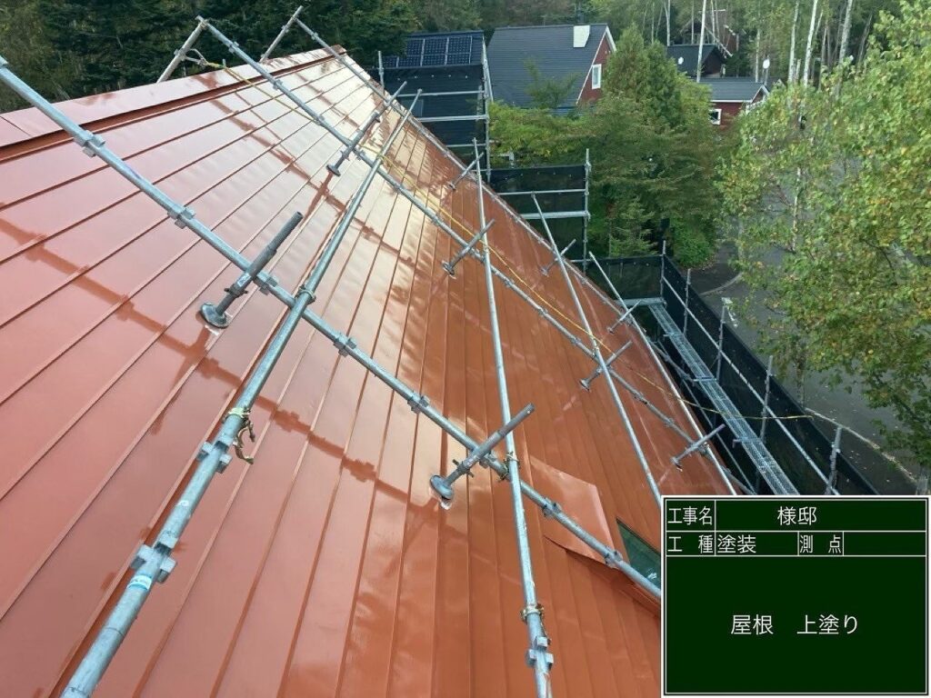 屋根塗装施工中:レディシュオレンジでの上塗り作業