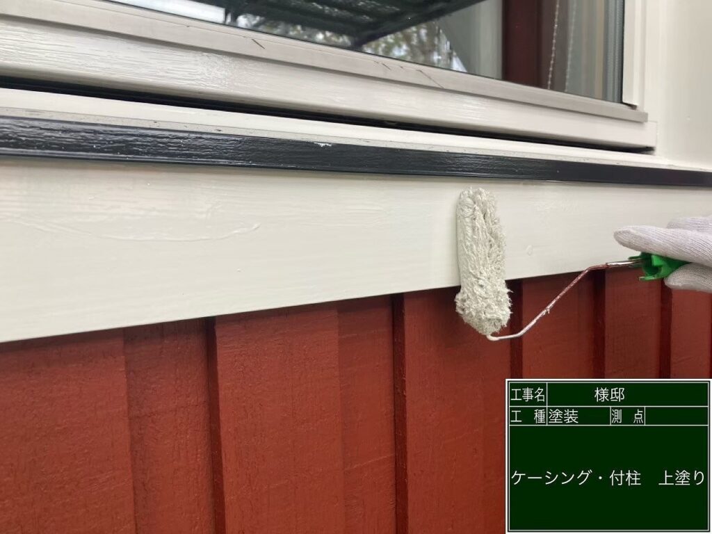 外壁塗装施工中:木板外壁への丁寧な塗装作業の様子