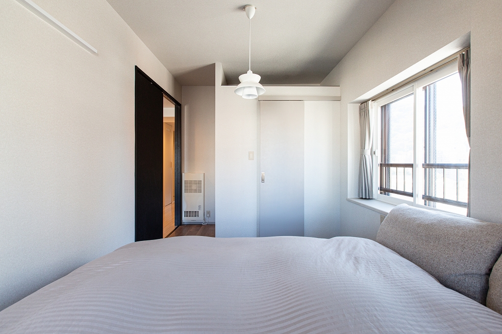 リノベーション後：ベージュトーンで統一された寝室、造作ウォークインクローゼット付き