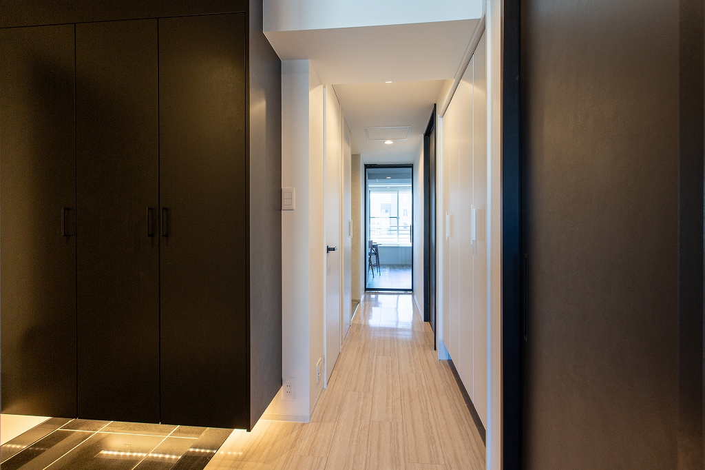 リノベーション後：ホワイトで統一されたノイズレスな廊下、大建工業の石目柄フローリング