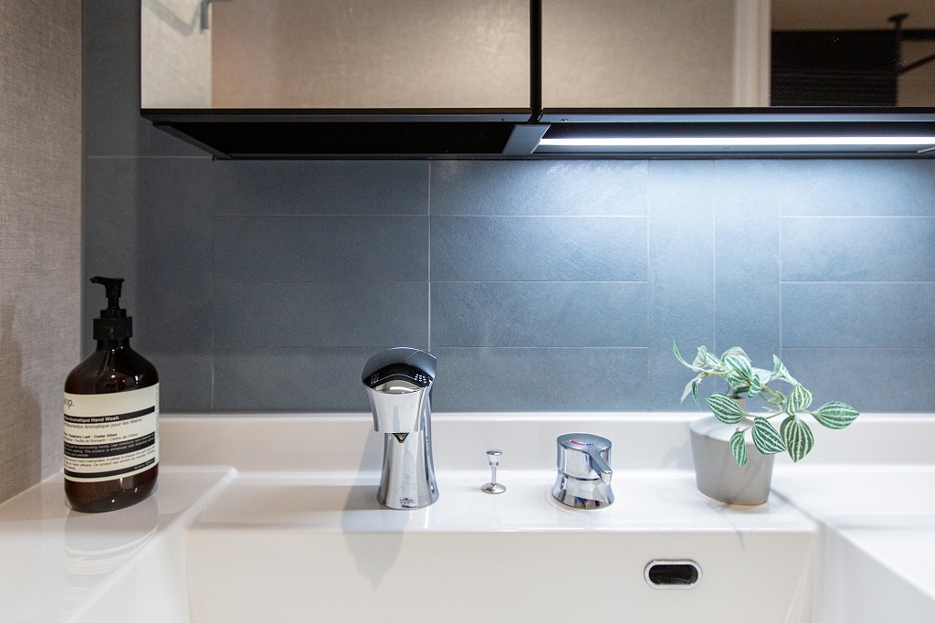 リノベーション後：TOTO GG3と造作カウンター、間接照明のあるグレー系トイレ空間