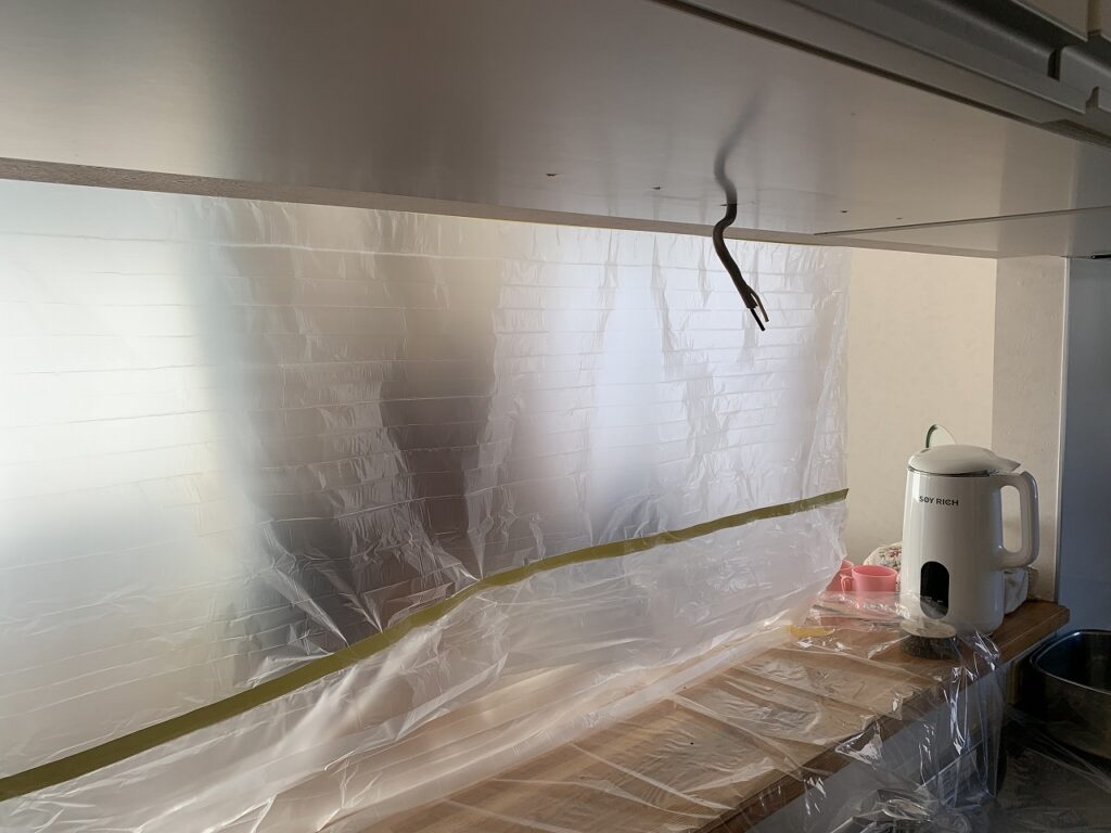 施工中：養生をしたキッチン手元灯取付作業の様子