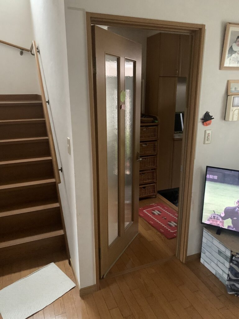 リフォーム前：歪みと穴のある居間のドア